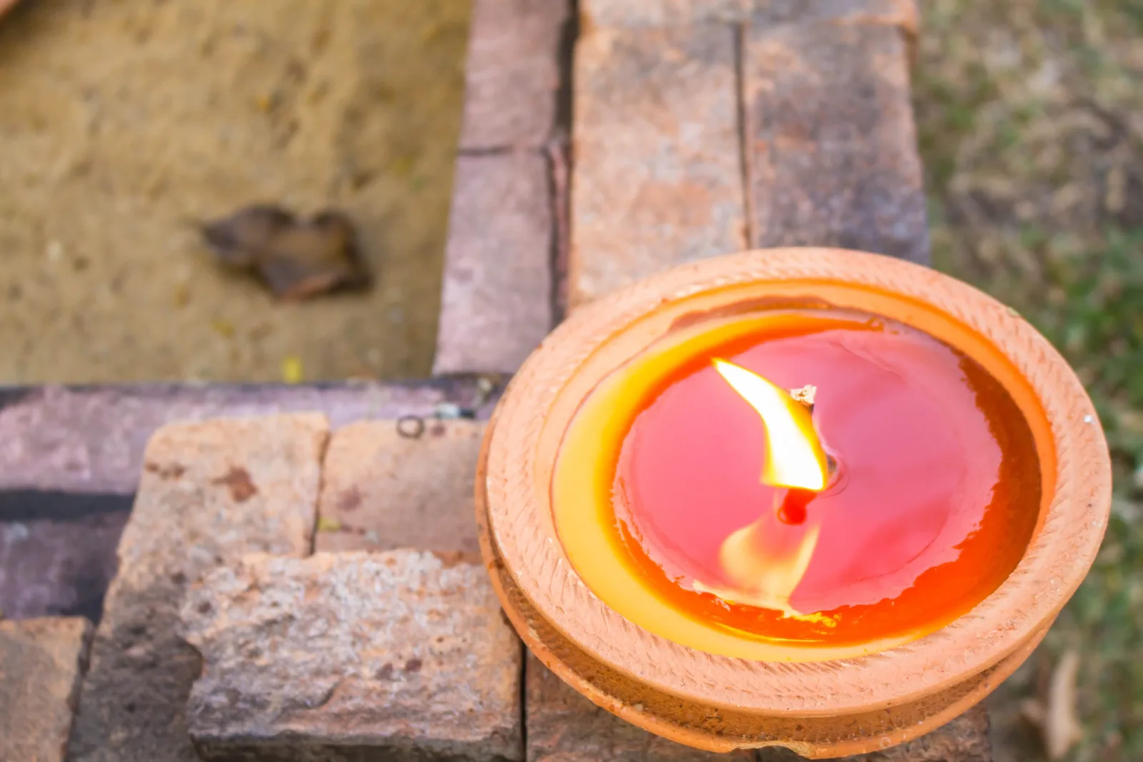 Citronella candle burning in a stone wall niche
