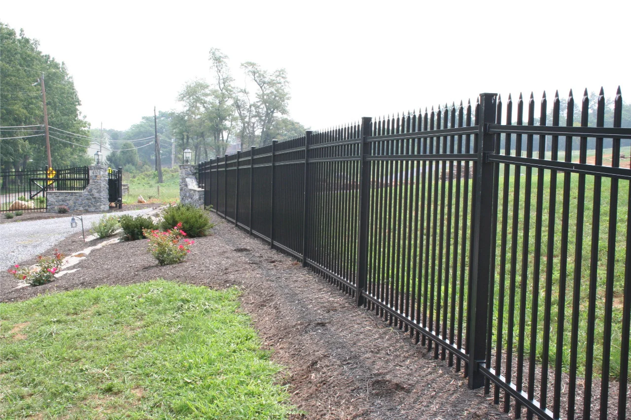 Black aluminum fence along a landscaped lawn