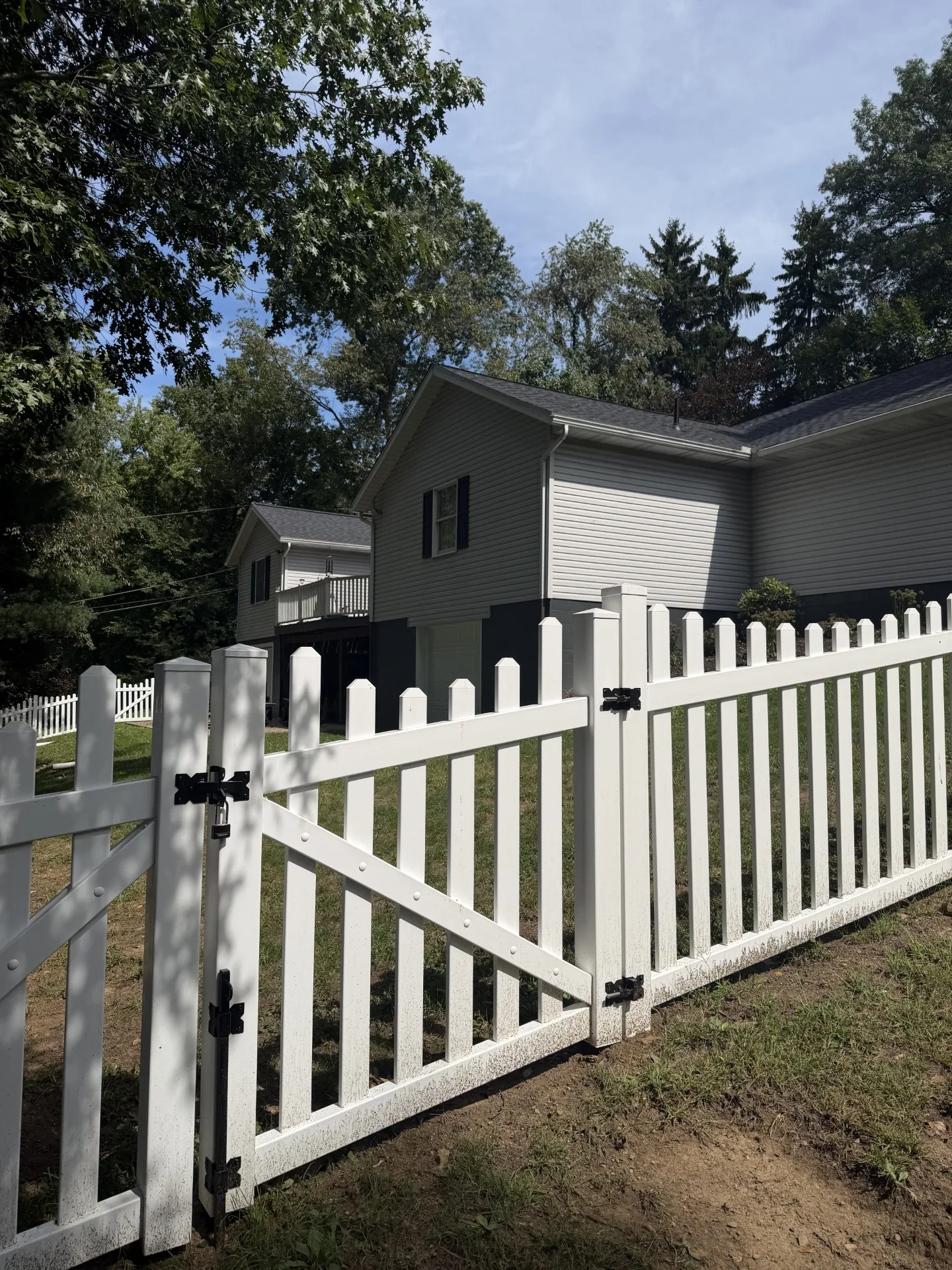 White picket fence with a double gate in a side yard