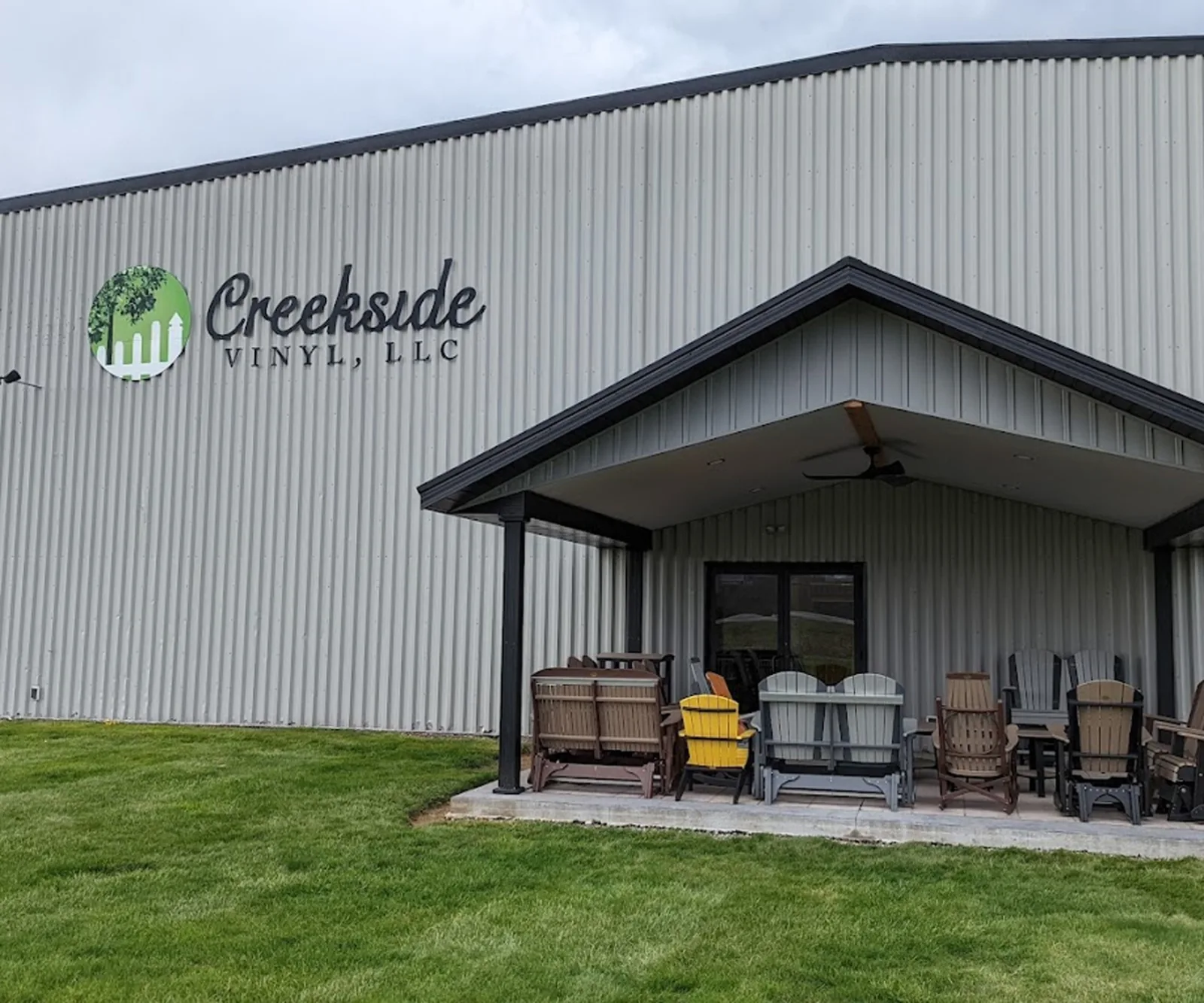 The Creekside Vinyl showroom building in Fresno, Ohio, with outdoor furniture on display under the porch