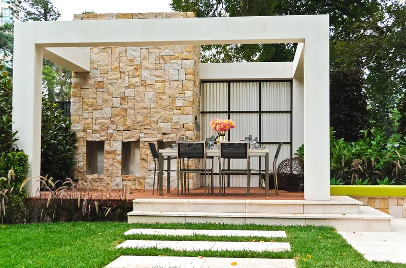 Outdoor living space with a stone fireplace wall and a dining set