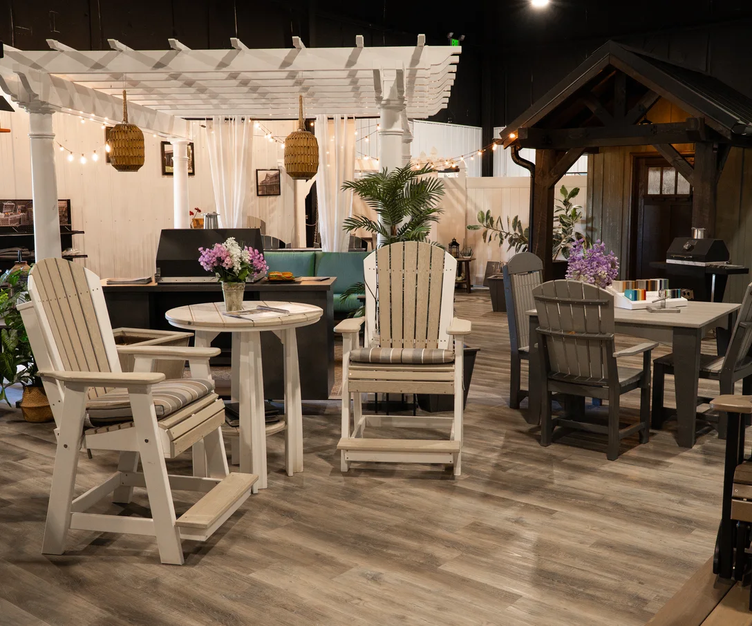 Poly outdoor furniture arranged under a white pergola inside the Creekside showroom